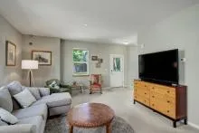 Living room with a couch, ottoman, TV, and wall art.