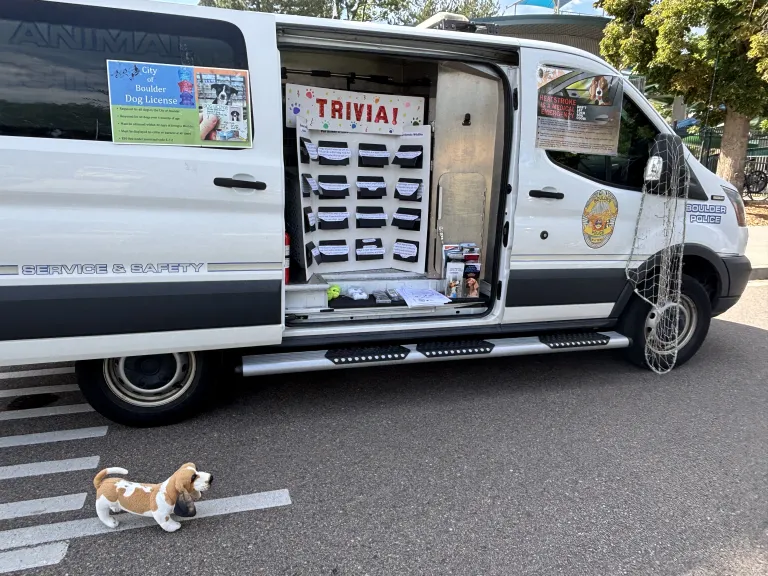 Large white van with a board of trivia questions inside the side door