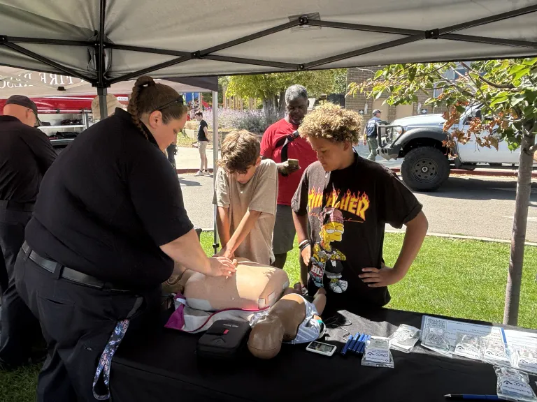 Firefighter showing a kid how to do CPR