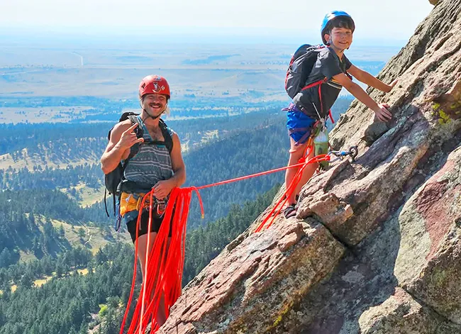 David Hebel and his son on the slanted 3rd Flatiron with Boulder far below.