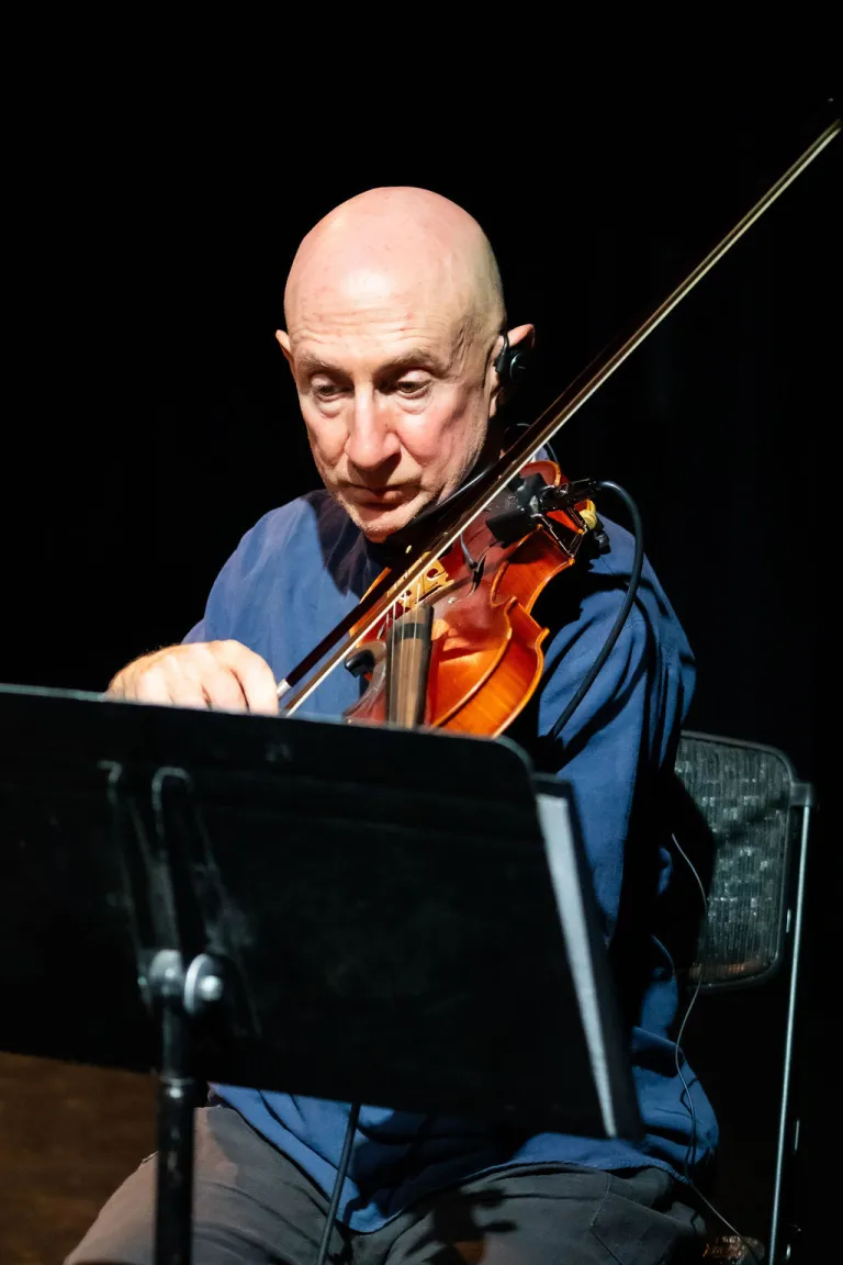 Violinist playing during the Motus Elevate Boulder monologue performance.
