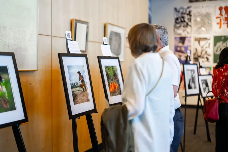 Community members viewing photographs from Elevate Boulder participants in the Dairy Arts Center library.