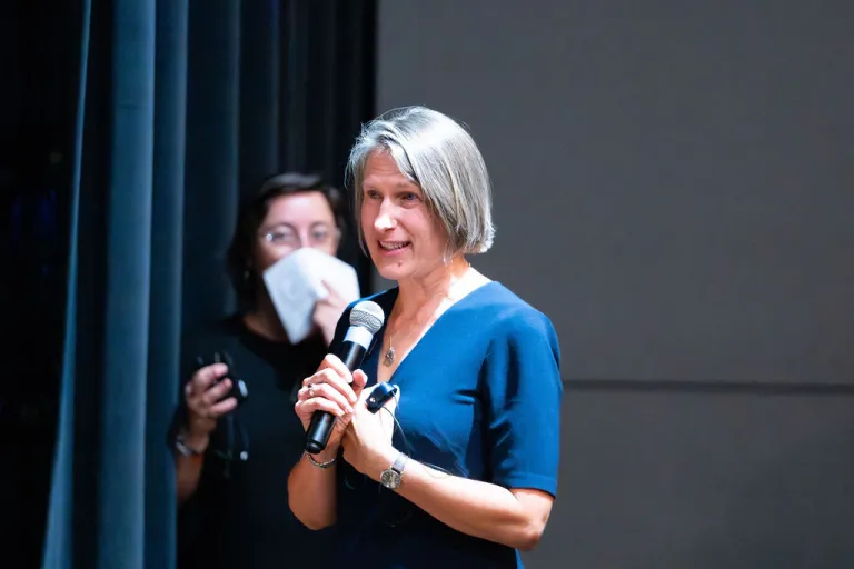 Elizabeth Crowe speaking on stage during the Elevate Boulder monologue performance at Motus Theater.
