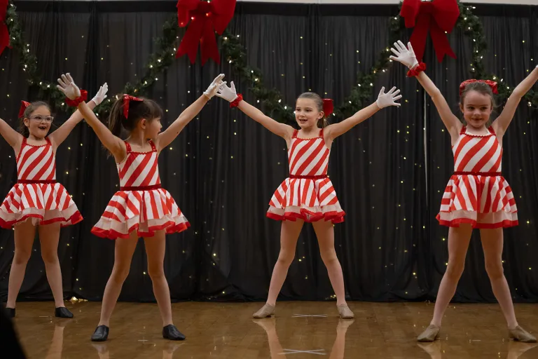 Dancers in white and red stripes performing in Winter Dance Concert 2024