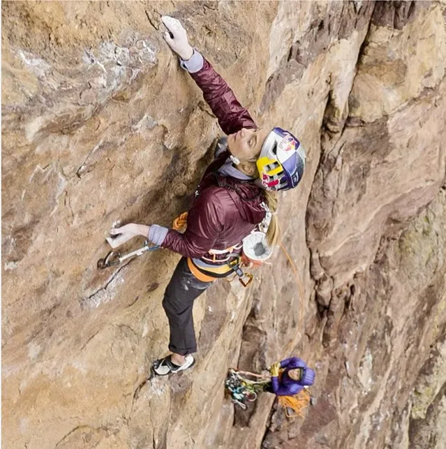Looking down from above at two women climbers on a rock face.