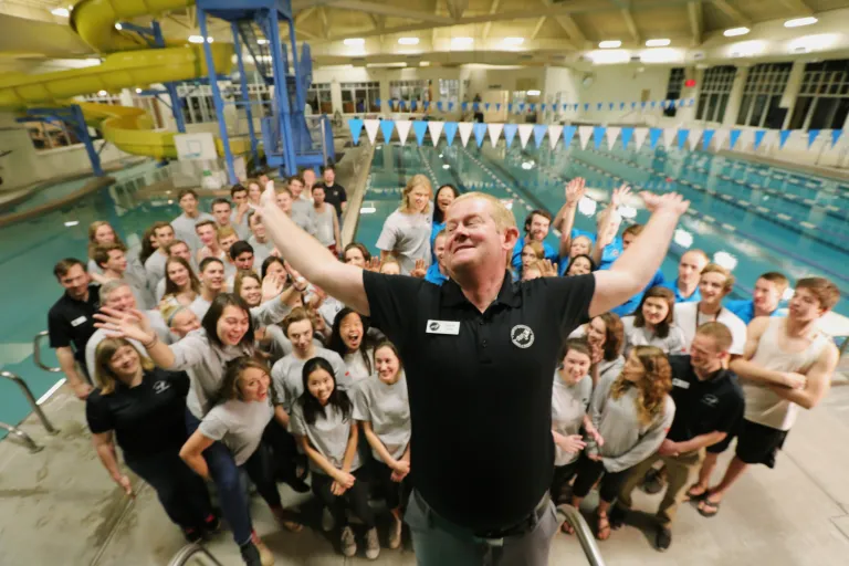 Parks and rec staff standing in front of a pool at a rec center