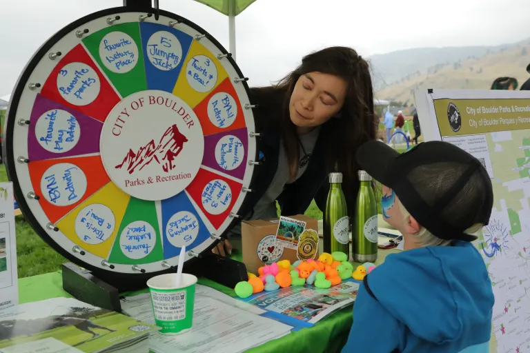 City employee interacting with a young community member at What's Up Boulder
