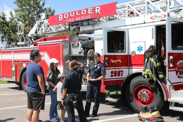 Boulder Fire-Rescue staff speaking with community members in front of a fire engine at What's Up Boulder event