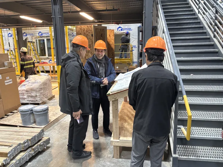 A delegation from the Japan Off-site Construction Association reviews floor plans at BoulderMOD.
