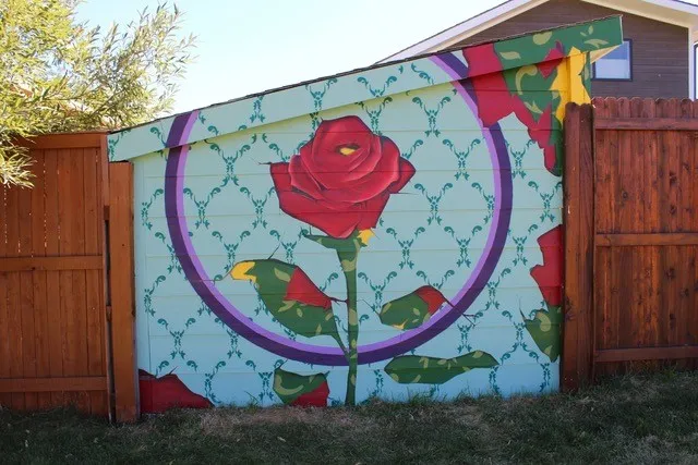 Mural of a rose on the side of a fence