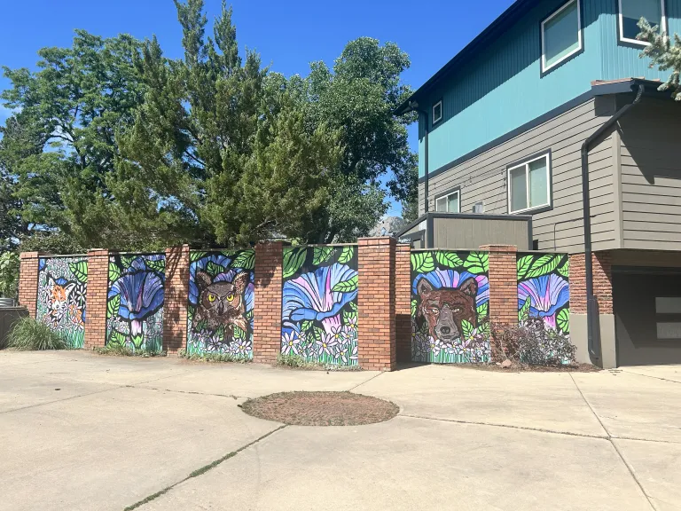 Mural of bears and flowers on the side of a fence
