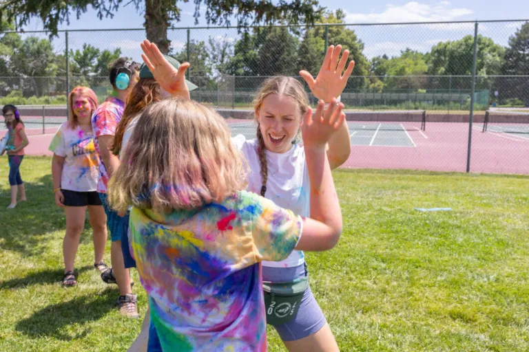 Two campers high fiving at the color run