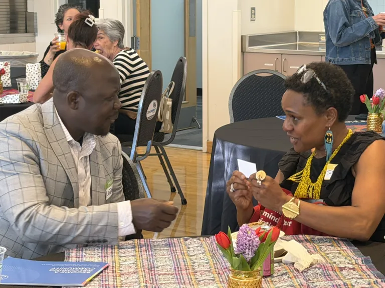 City council member and community organization leader, sitting at a table in discussion