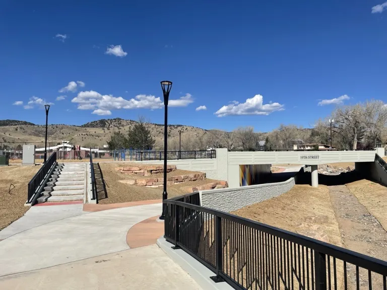 multi-use path and bike/pedestrian underpass beneath road; stairs lead up to road