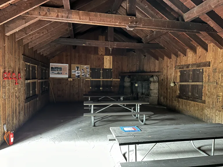 Inside Green Mountain Lodge, a rustic building with picnic tables.