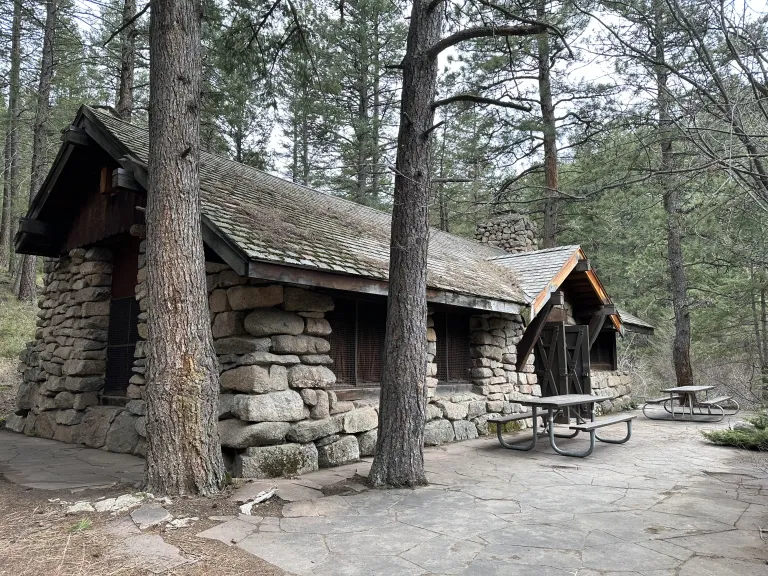 Green Mountain Lodge, stone building surrounded by pine trees.