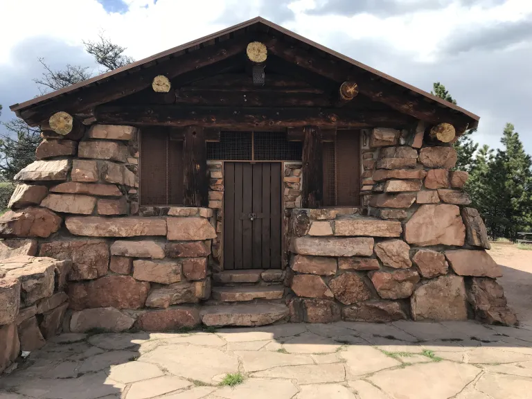 The front of the Halfway House, a stone building with large wooden beams poking out along the roof line.