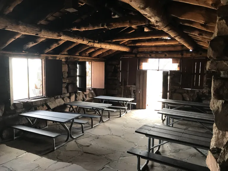 Inside the Halfway House with six picnic tables, two windows and the door let in light.