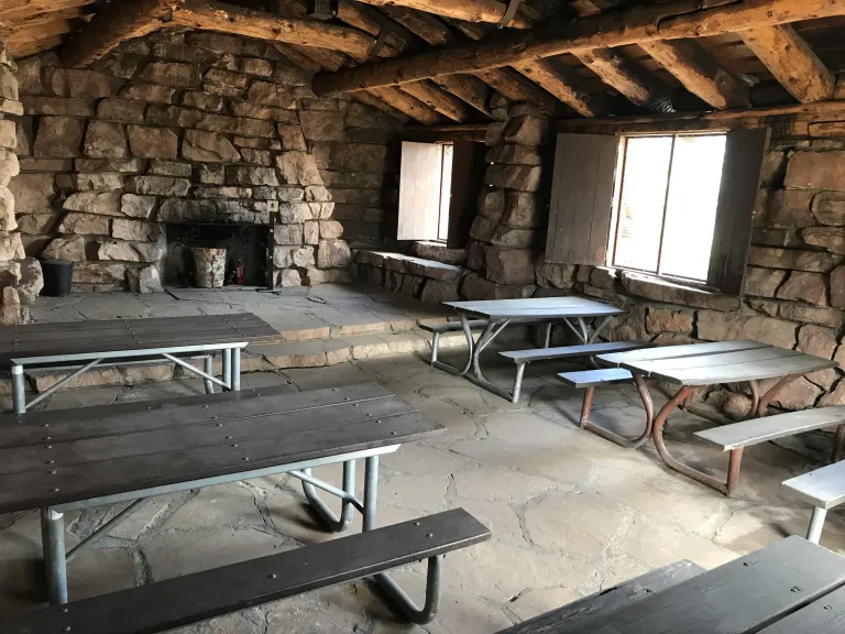 Inside the Halfway House there are six picnic tables and a stone platform at the back with a non-operational fireplace. 
