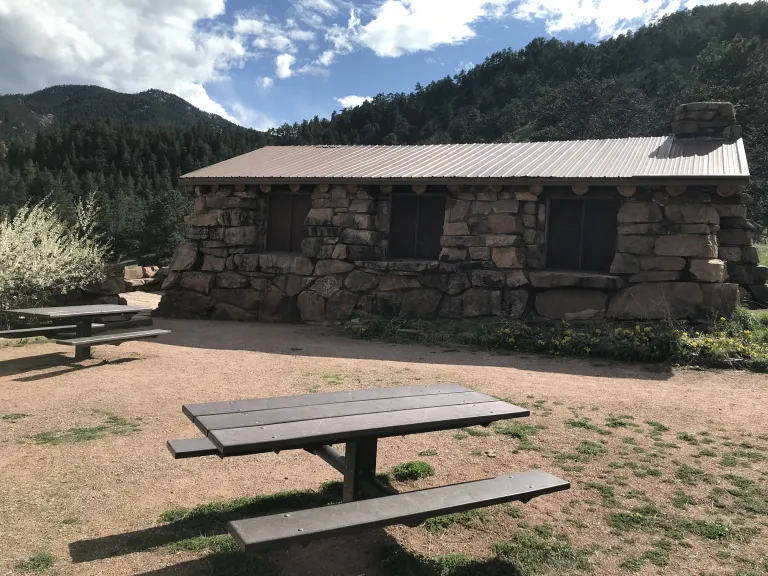 Two picnic tables with the Halfway House in the background.