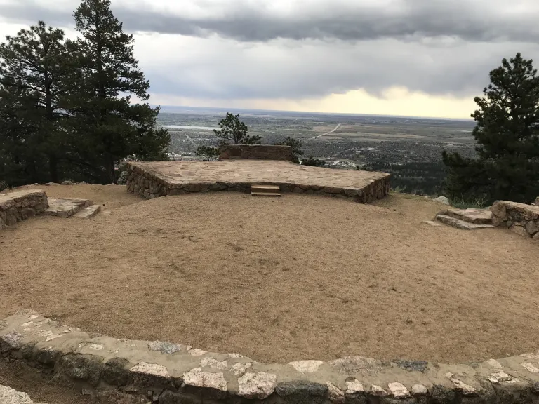The Sunrise Amphitheater stone stage is visible across the center circle from the first row of stone seats.