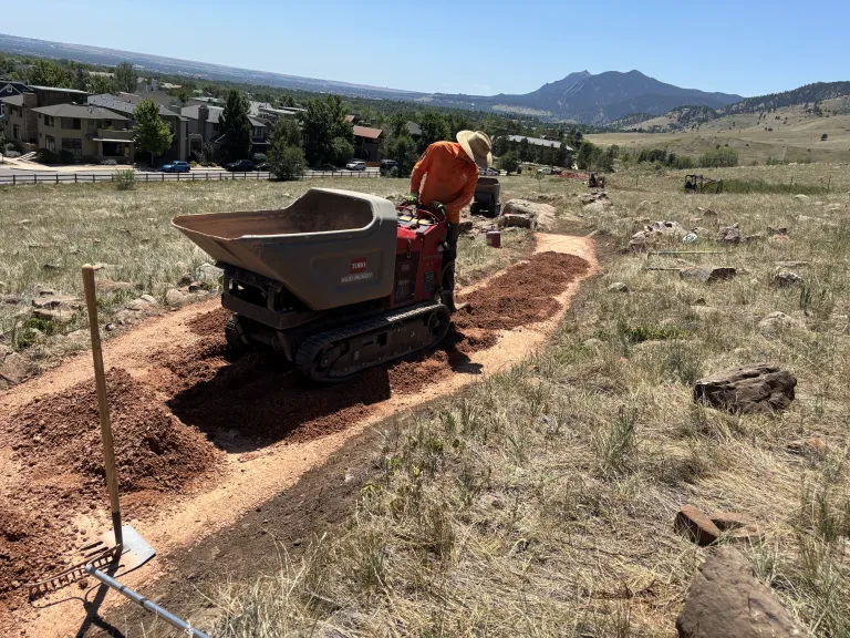 A man pushing a small piece of construction equipment on the North Foothills Trail