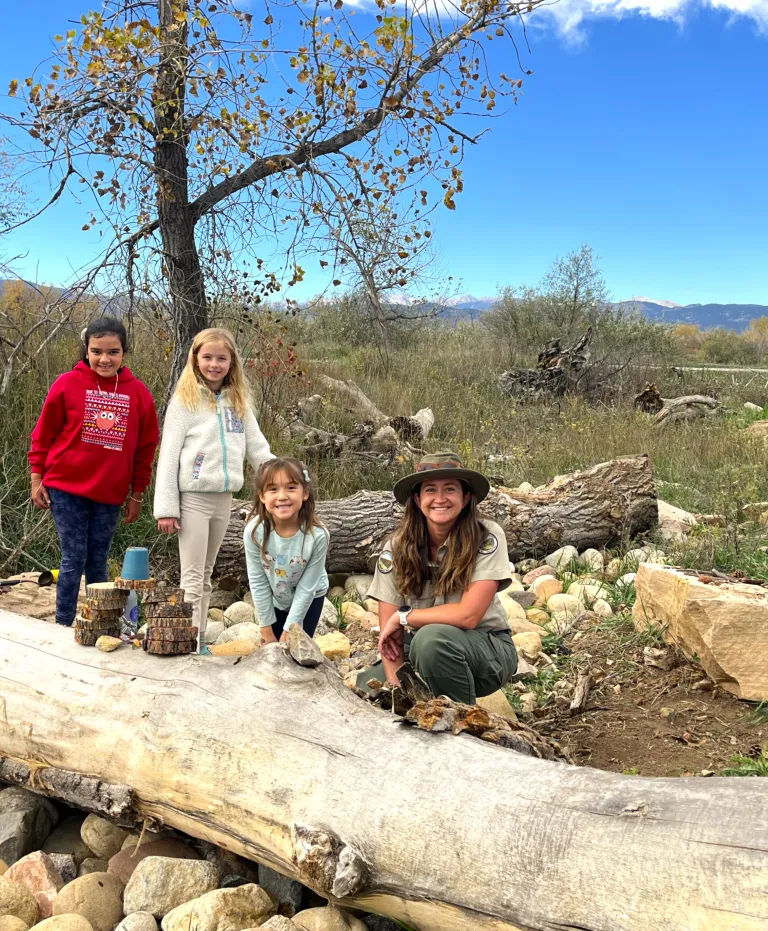 Three children and an OSMP naturalist in the Nature Discovery Zone at Sawhill Ponds
