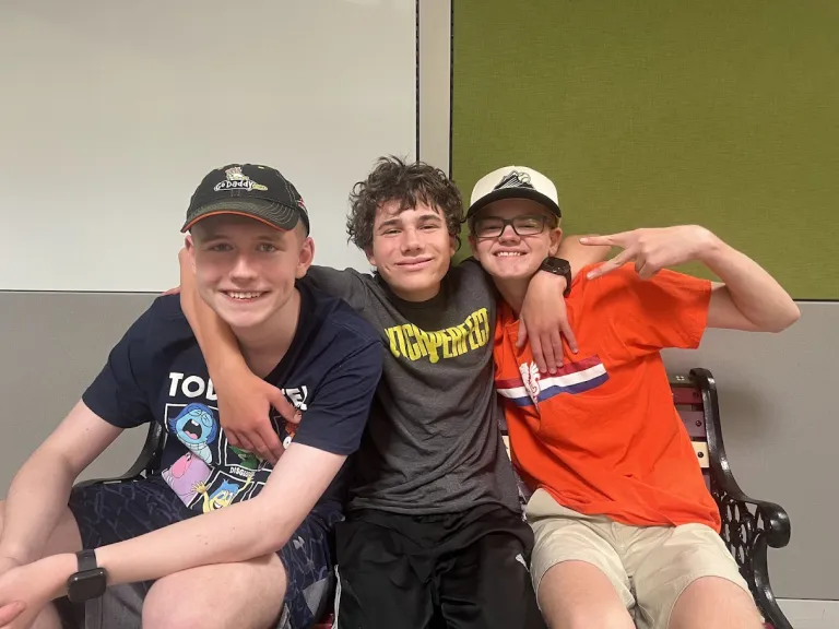 Three children posing and smiling for a photo.