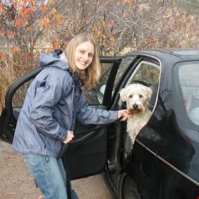 Woman getting dog out at trailhead