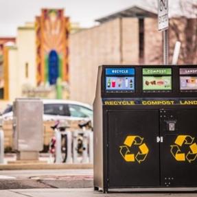 Photo of a trash, compost, recycle bin, Boulder Theater in the background.