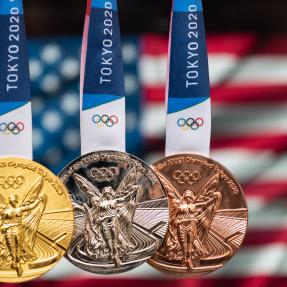 Gold, silver and bronze Tokyo Olympics Medals hang in front of the US flag