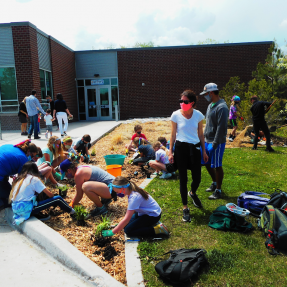 Several volunteers plant a pollinator garden at Martin Acres elementary school, Creekside Elementary.