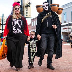 Family with Halloween costumes walking on Pearl Street 