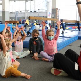 Kids with hands up in gymnastics
