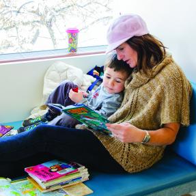 Child reading with mom in children's library 