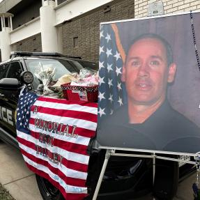 Officer Eric Talley photo in front of police car memorial