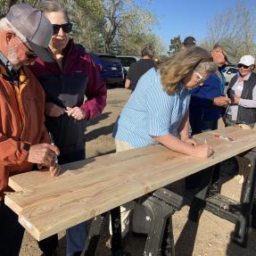 People signing two by fours that will be used in the new Ponderosa homes
