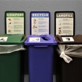 Compost, recycle and landfills bins lined up against a wall