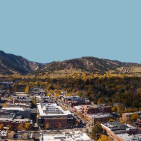 Aerial view of Boulder buildings with Flatirons in the distance