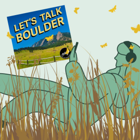 Person lying in the grass listening to Let's Talk Boulder podcast