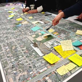 People writing down feedback and pointing to a map of Iris Avenue.