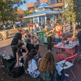 Children and adults interacting with an art station.