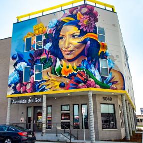 Colorful mural on side of a building featuring a woman's face and flowers