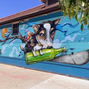 A mural of a dog with a backpack full of random objects 