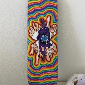 A vibrant form in the middle of a rainbow-colored skateboard 
