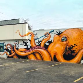 A mural of an orange octopus with a tooth and a toothbrush