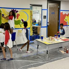 Abstract shapes with students painting the mural