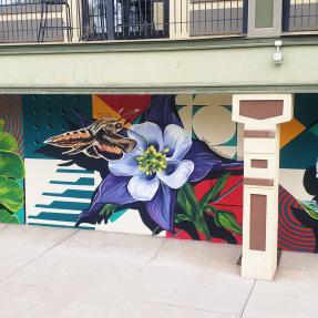 Mural with flowers and a moth in front of geometric patterns