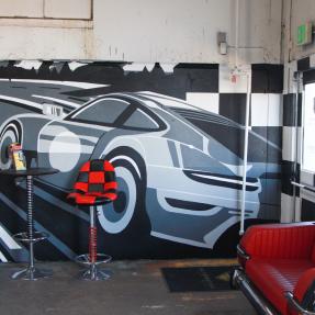 Multi-wall mural of a car racing along a road