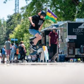 Skateboarder on 13th Street with food trucks behind them